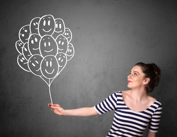 Mujer sosteniendo un montón de globos sonrientes — Foto de Stock