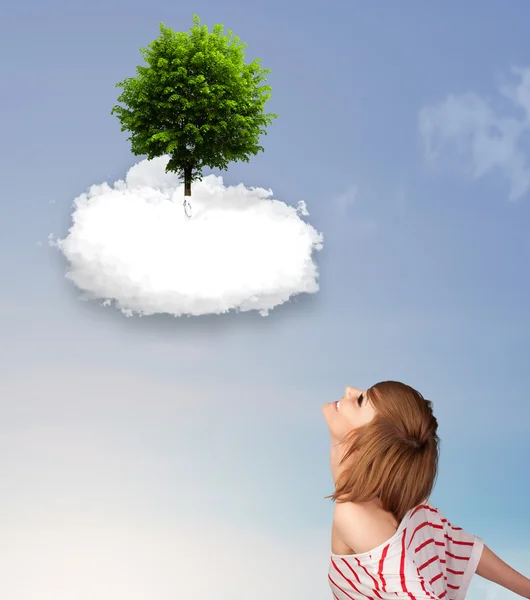 Niña apuntando a un árbol verde en la parte superior de una nube blanca — Foto de Stock