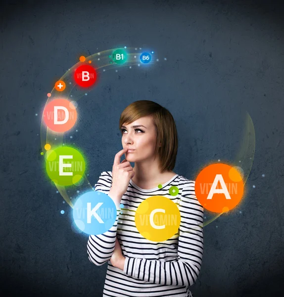 Young woman thinking with vitamins circulation around her head — Stock Photo, Image