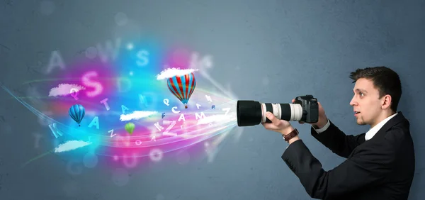 Handsome photographer with camera and abstract imaginary — Stock Photo, Image