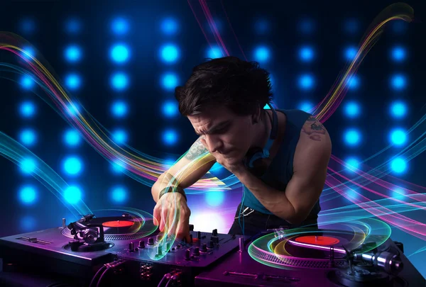 Jovem Dj misturando registros com luzes coloridas — Fotografia de Stock