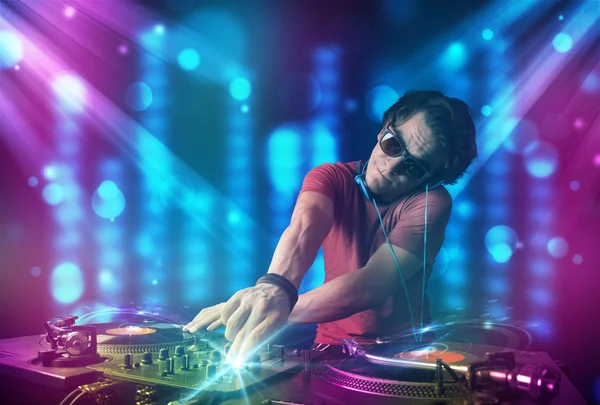 DJ miksowania muzyki w klubie z niebieski i fioletowy światła — Zdjęcie stockowe