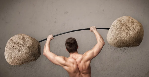 Hombre muscular levantando grandes pesos de piedra de roca —  Fotos de Stock