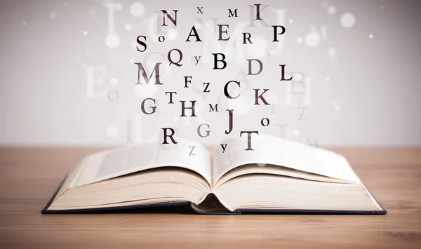Geopend boek met vliegende letters — Stockfoto