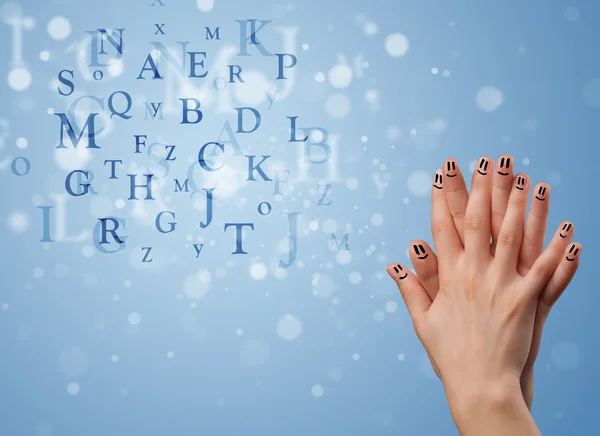 Happy smiley fingers looking at mixture of bokeh letters — Stock Photo, Image