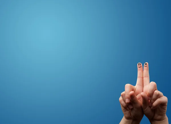 Happy smiley face fingers looking at empty blue background copy — Stock Photo, Image