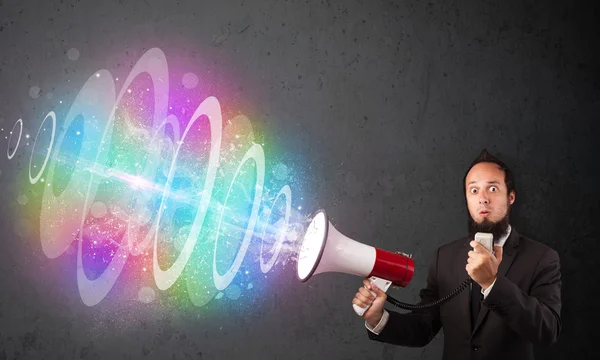 L'homme crie dans un haut-parleur et un faisceau d'énergie coloré sort — Photo