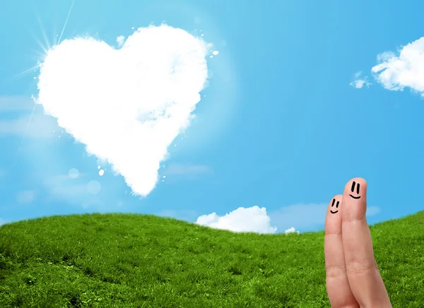 Happy smiley fingers looking at heart shaped cloud — Stock Photo, Image