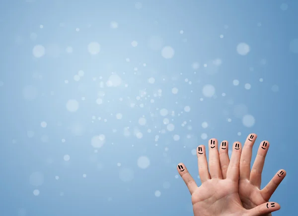 Sorrisos dedo feliz com fundo bokeh azul vazio — Fotografia de Stock