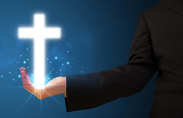 Glowing cross in the hand of a businessman — Stock Photo, Image