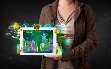 Elle çizilmiş şehir manzaralı tablet gösteren genç kişi