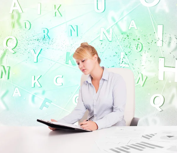 Zakelijke vrouw aan het bureau met groene woord cloud — Stockfoto