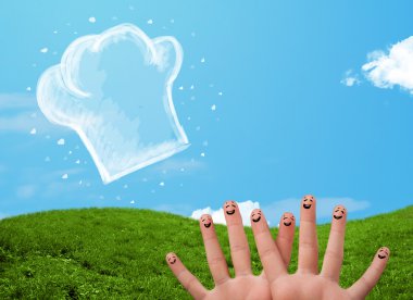 Mutlu gülen yüzlü parmaklar aşçı şapkasının resmine bakıyor.