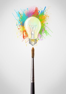 renkli boya sıçraması ve ampul ile fırça yakın çekim