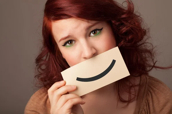 Feliz bonita mujer sosteniendo tarjeta con divertido smiley —  Fotos de Stock
