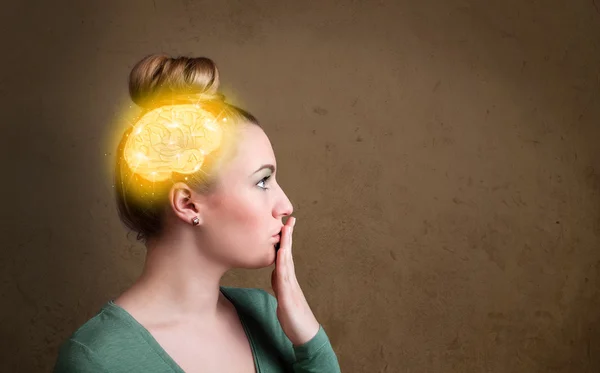 Young girl thinking with glowing brain illustration — Stock Photo, Image