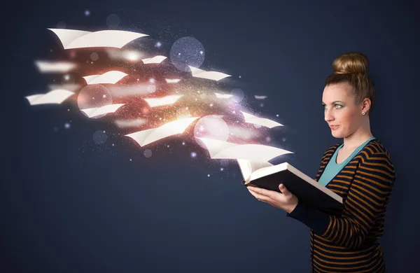 Young lady reading a book with flying sheets coming out of the b — Stockfoto