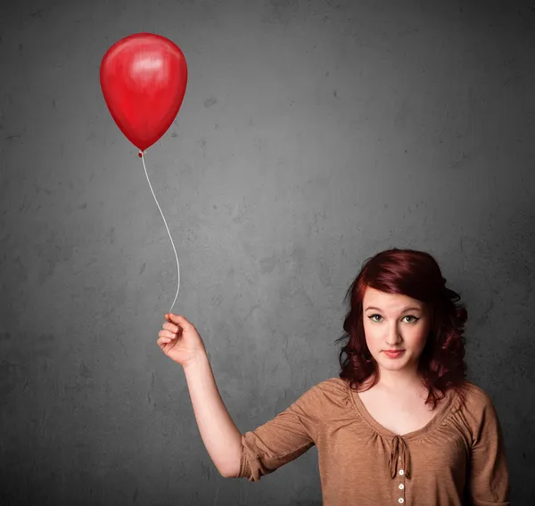 Kvinna som håller en röd ballong — Stockfoto