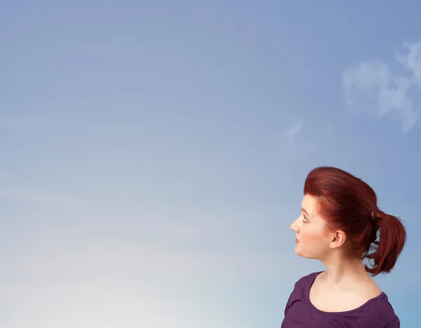 Dívka při pohledu na modré oblohy copyspace — Stock fotografie