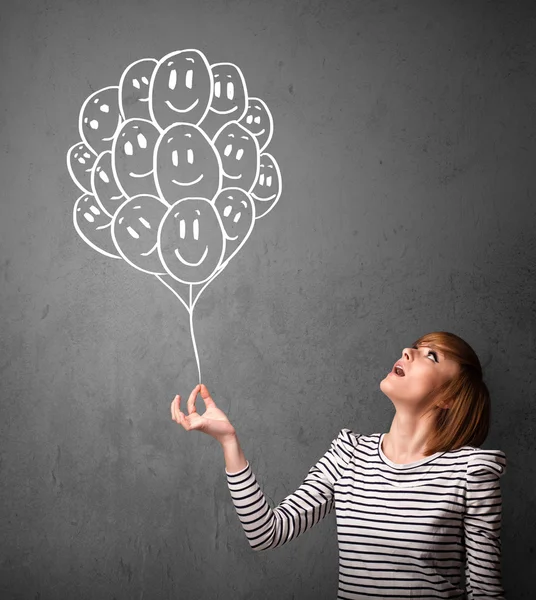 Woman holding a bunch of smiling balloons — Stock Photo, Image