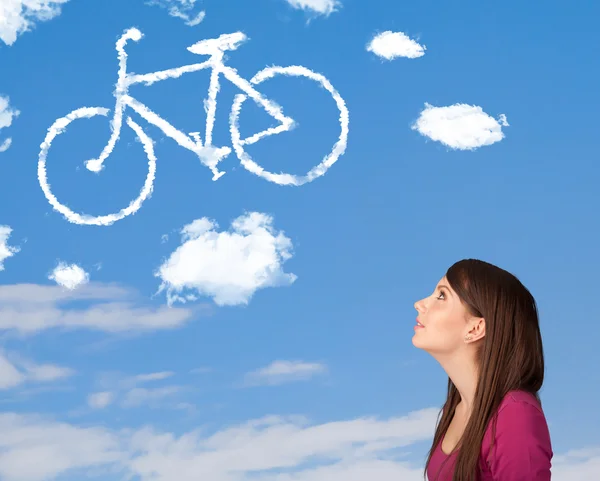 Девушка смотрит на велосипедные облака на голубом небе — стоковое фото