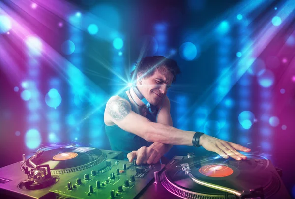 Dj misturando música em um clube com luzes azuis e roxas — Fotografia de Stock