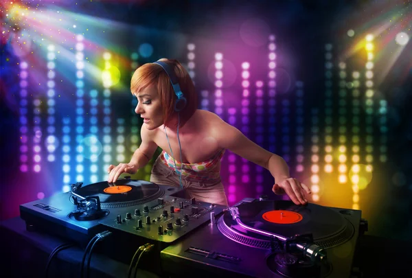 Chica Dj tocando canciones en una discoteca con espectáculo de luz — Foto de Stock