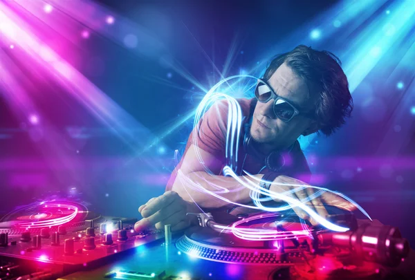 Energiska dj blandande musik med kraftfulla ljuseffekter — Stockfoto