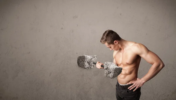 Hombre muscular levantando grandes pesos de piedra de roca — Foto de Stock