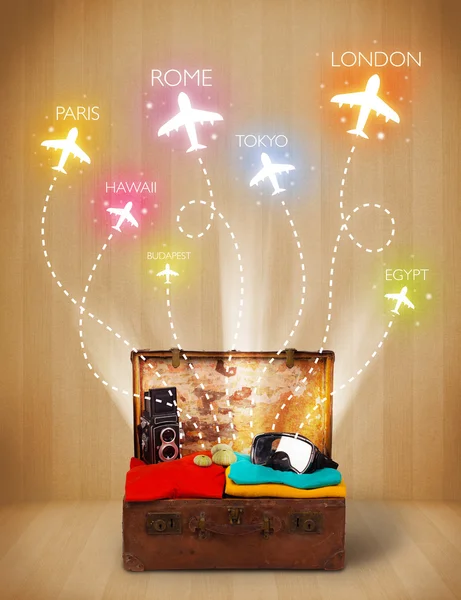 Cestovní tašku s oblečením a barevné letadla létají z — Stock fotografie