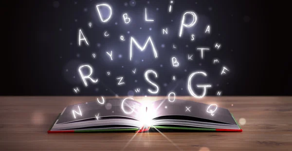 Open book with glowing letters flying out — Stock Photo, Image