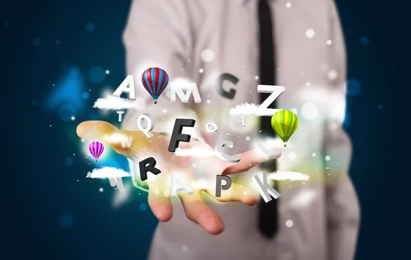 Young businessman presenting magical clouds with letters and bal — Stock Photo, Image