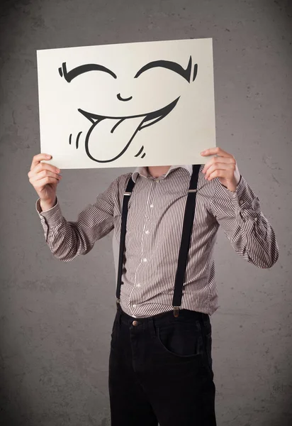 Podnikatel drží papír s legrační smajlíky před h — Stock fotografie