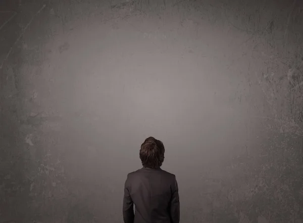 Επιχειρηματίας στέκεται μπροστά από ένα άδειο τοίχο — Φωτογραφία Αρχείου