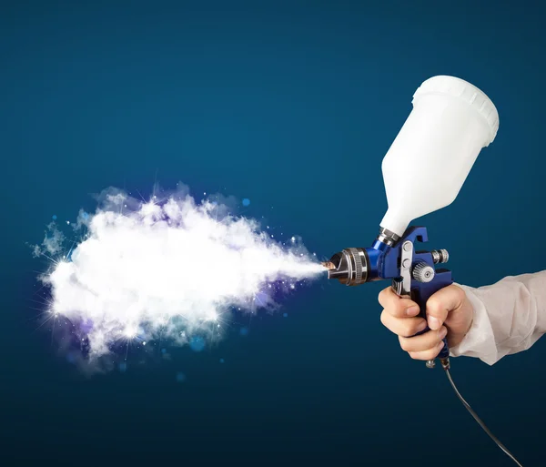 Schilder met airbrush pistool en witte magische rook — Stockfoto