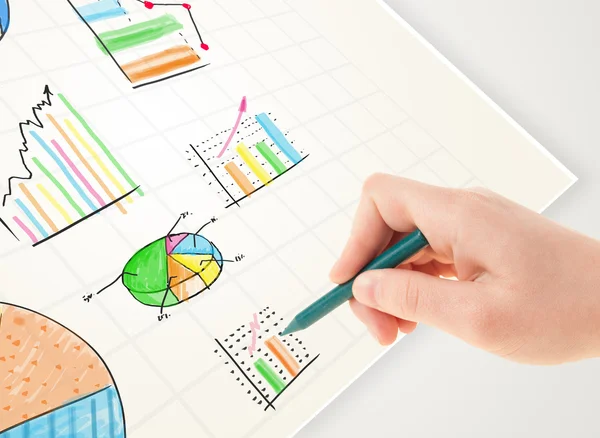 Affärsperson rita färgglada grafer och ikoner på papper — Stockfoto