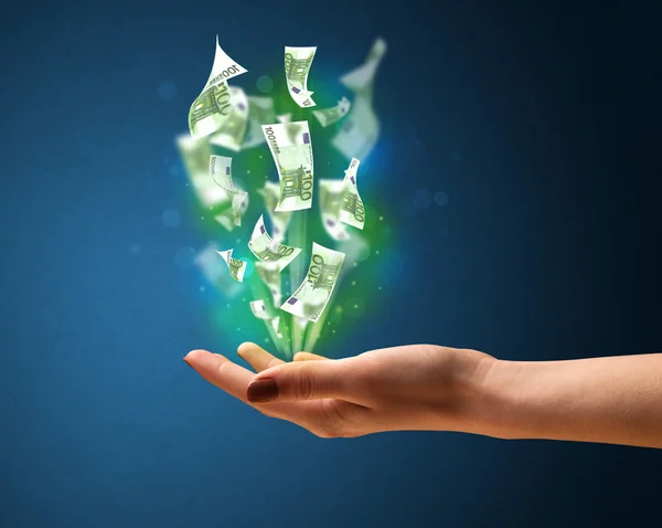 Glowing money in the hand of a woman — Stock Photo, Image