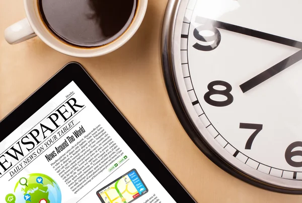 Tablet pc shows news on screen with a cup of coffee on a desk — Stock Photo, Image