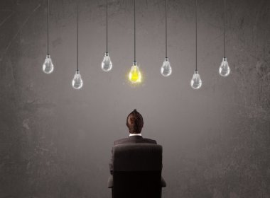 Businness guy in front of idea light bulbs concept clipart