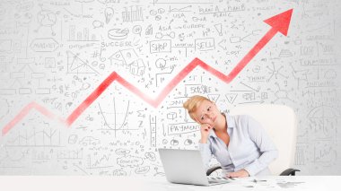 Piyasa diyagramlarıyla masada oturan iş kadını. 