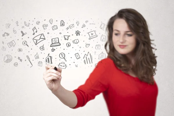 Mujer joven dibujando y dibujando iconos y símbolos —  Fotos de Stock