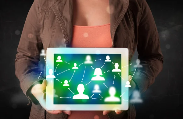 Jovem apresentando tablet com ícones de mídia social verde — Fotografia de Stock