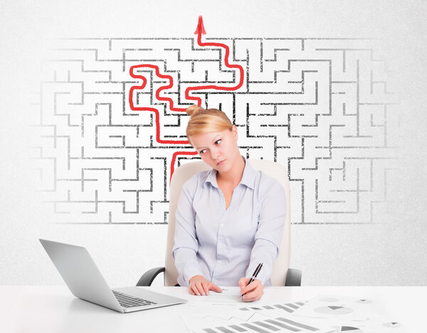 Деловая женщина за столом с лабиринтом и стрелой