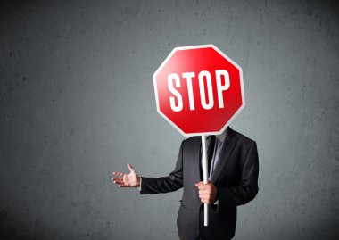 İşadamı elinde dur levhası tutuyor.