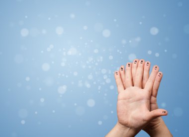 Boş mavi bokeh arkaplan ile mutlu parmak gülümsemeleri