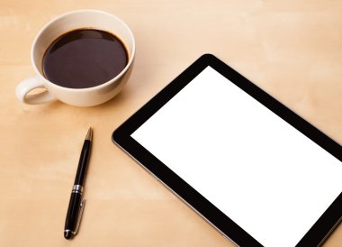 Boş alanı olan bir tablet bilgisayar ve masada bir fincan kahve.