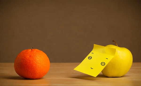 Apple with post-it note looking at orange — Stock Photo, Image