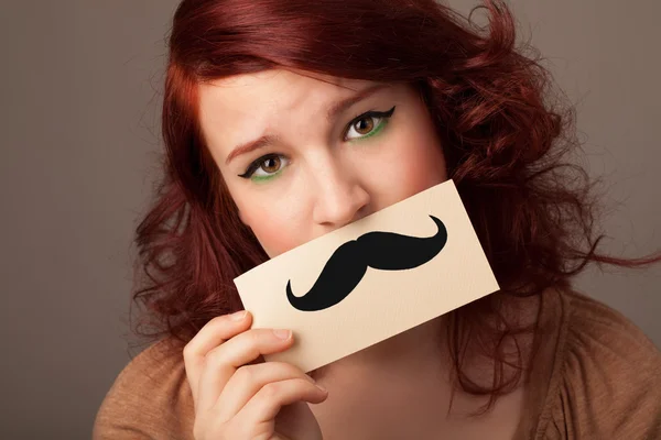 Happy cute girl holding paper with mustache drawing — Stock Photo, Image