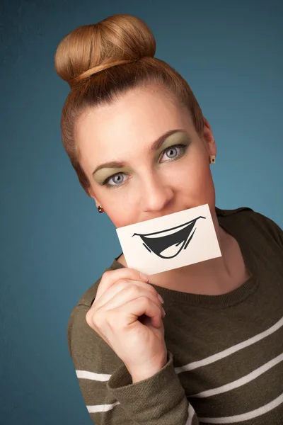 Feliz linda chica sosteniendo papel con divertido dibujo sonriente —  Fotos de Stock