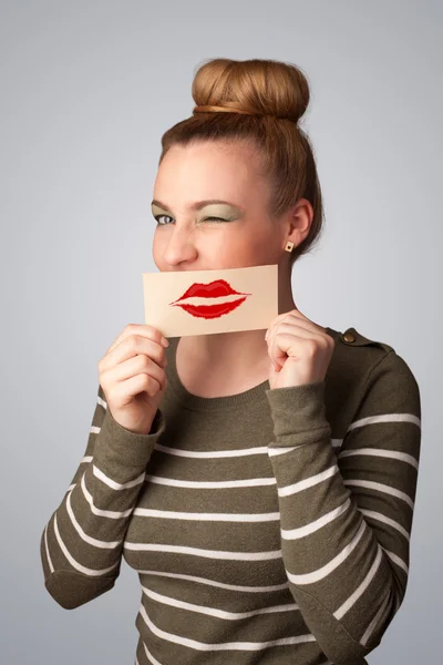 Feliz mulher bonita segurando cartão com marca batom beijo — Fotografia de Stock
